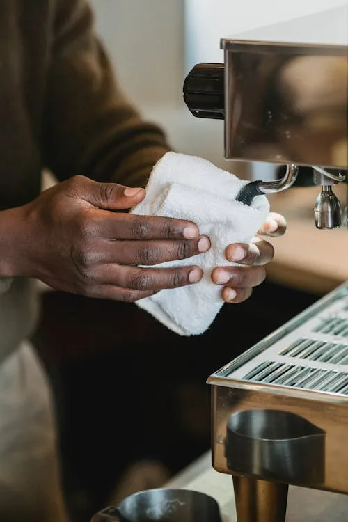 In process of cleaning the espresso machine, using a wet towel