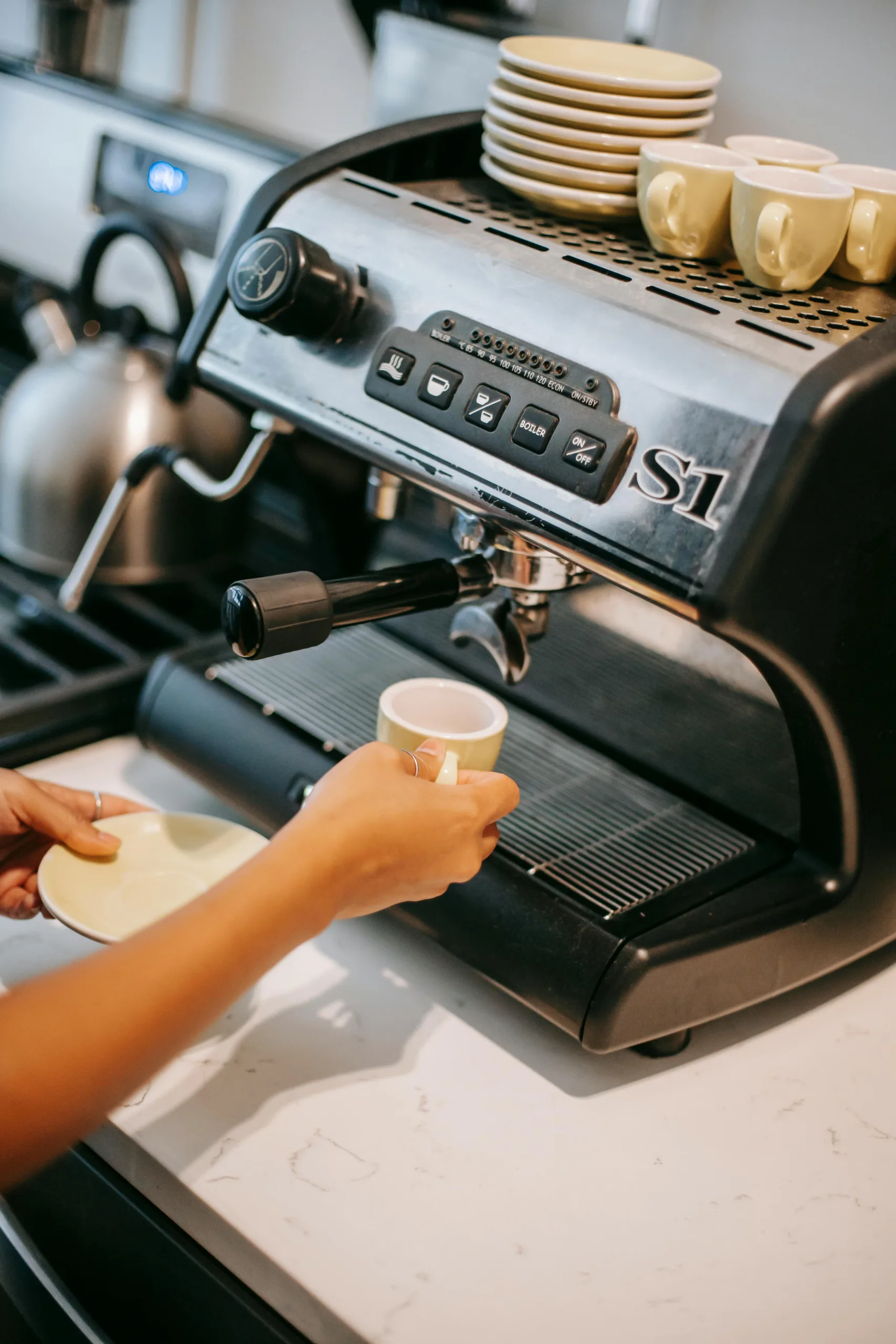 Home espresso machine on kitchen counter with fresh espresso cup