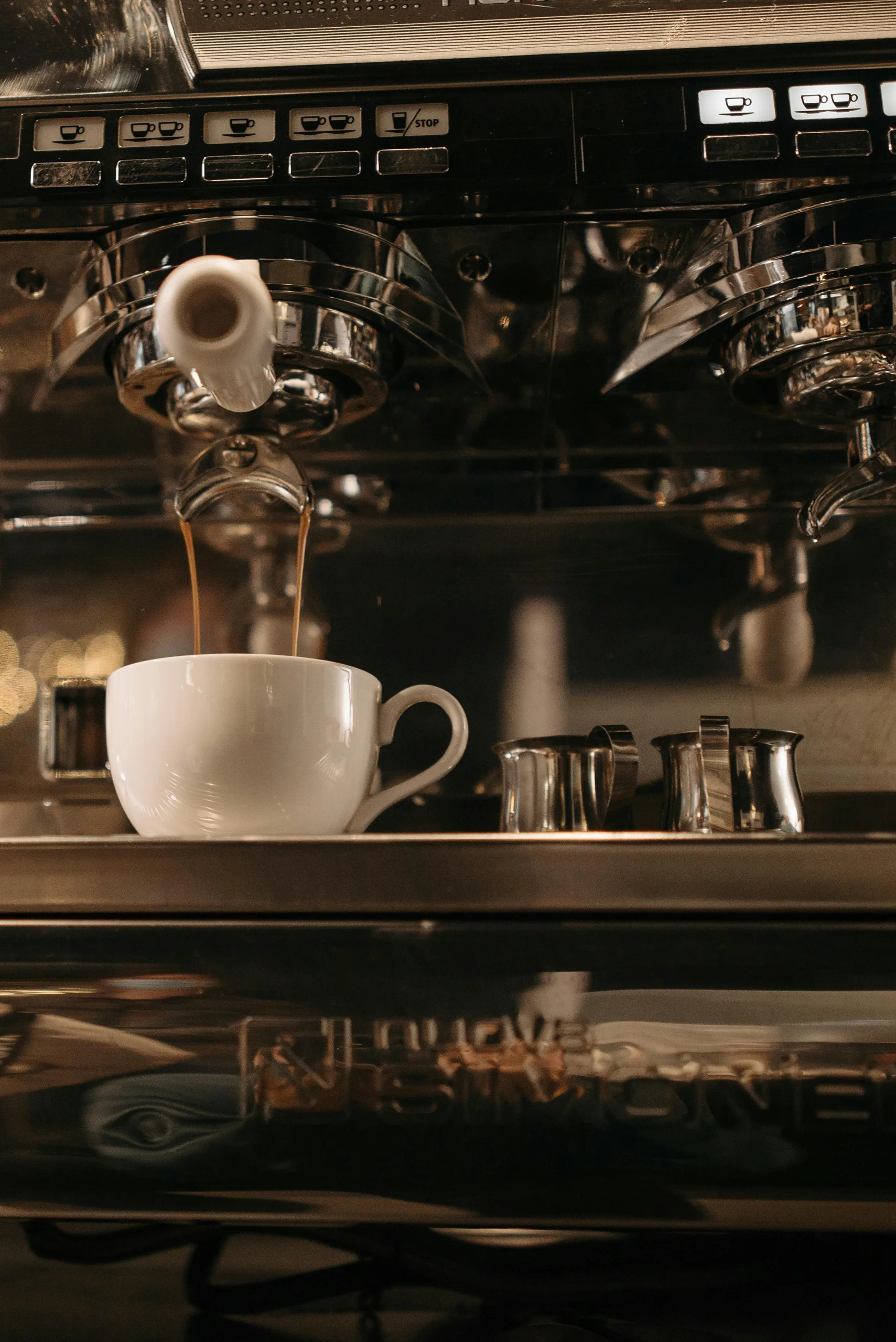 Close-up of temperature control and steam wand on espresso machine